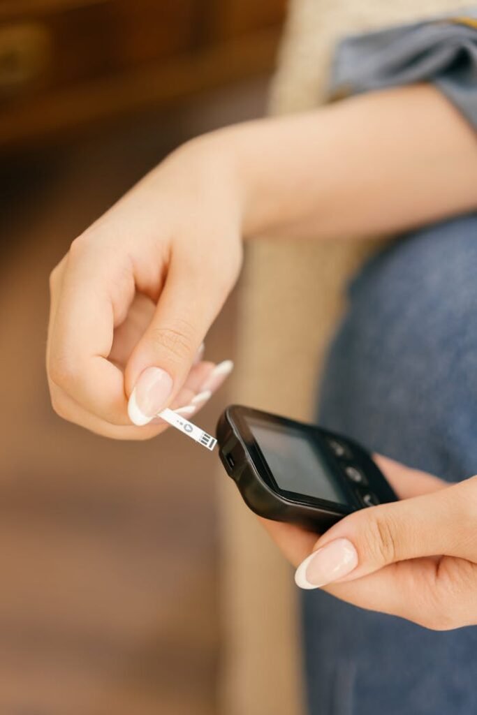 pexels photo 8669899 Hands holding a glucometer while inserting a test strip, highlighting blood sugar monitoring.